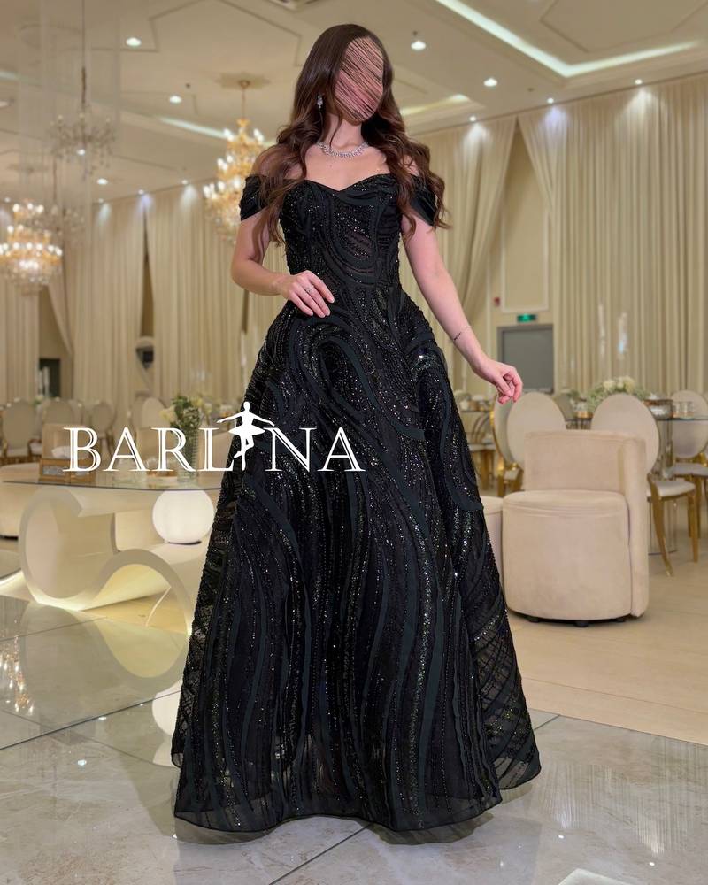 Black off-the-shoulder dress with wavy fabric