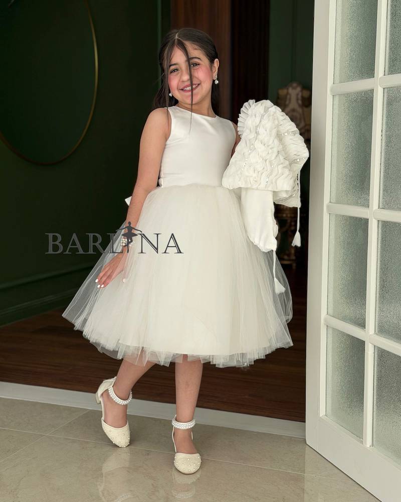 White girl's dress with a large ruffled shoulder