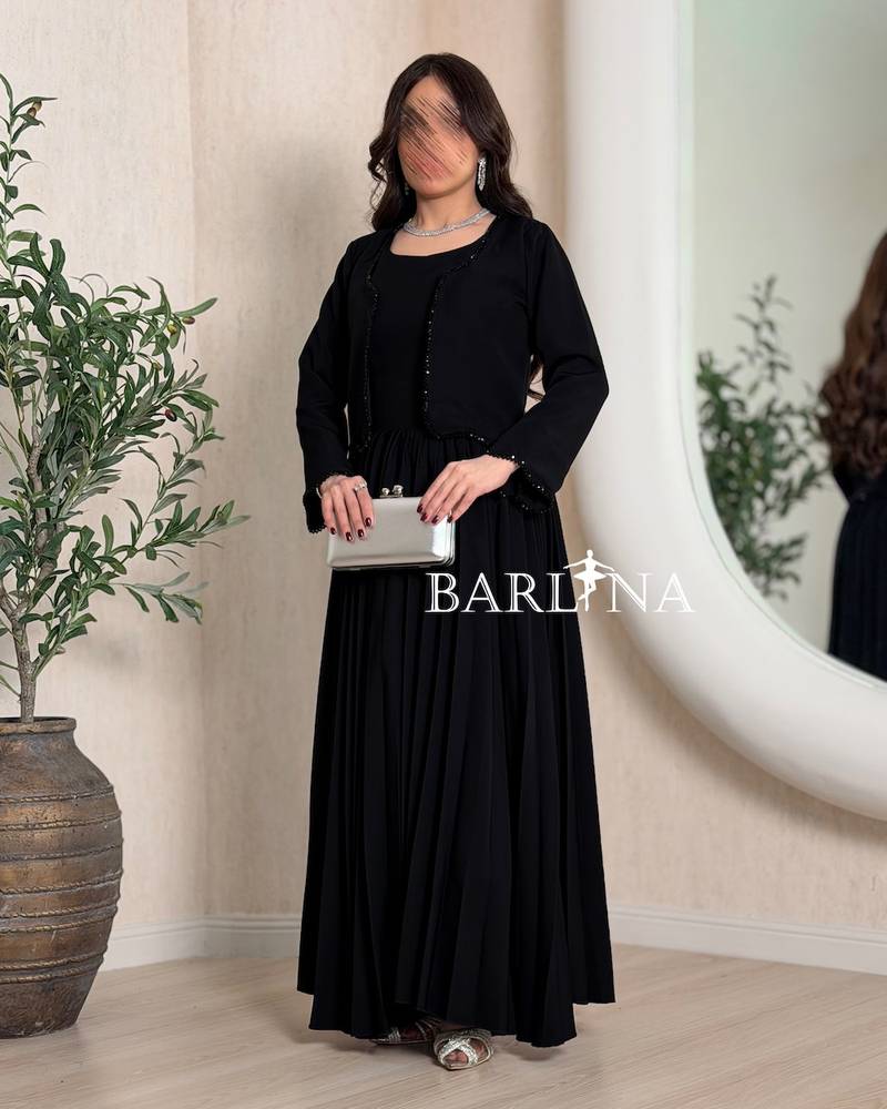 Black pleated dress and embroidered jacket