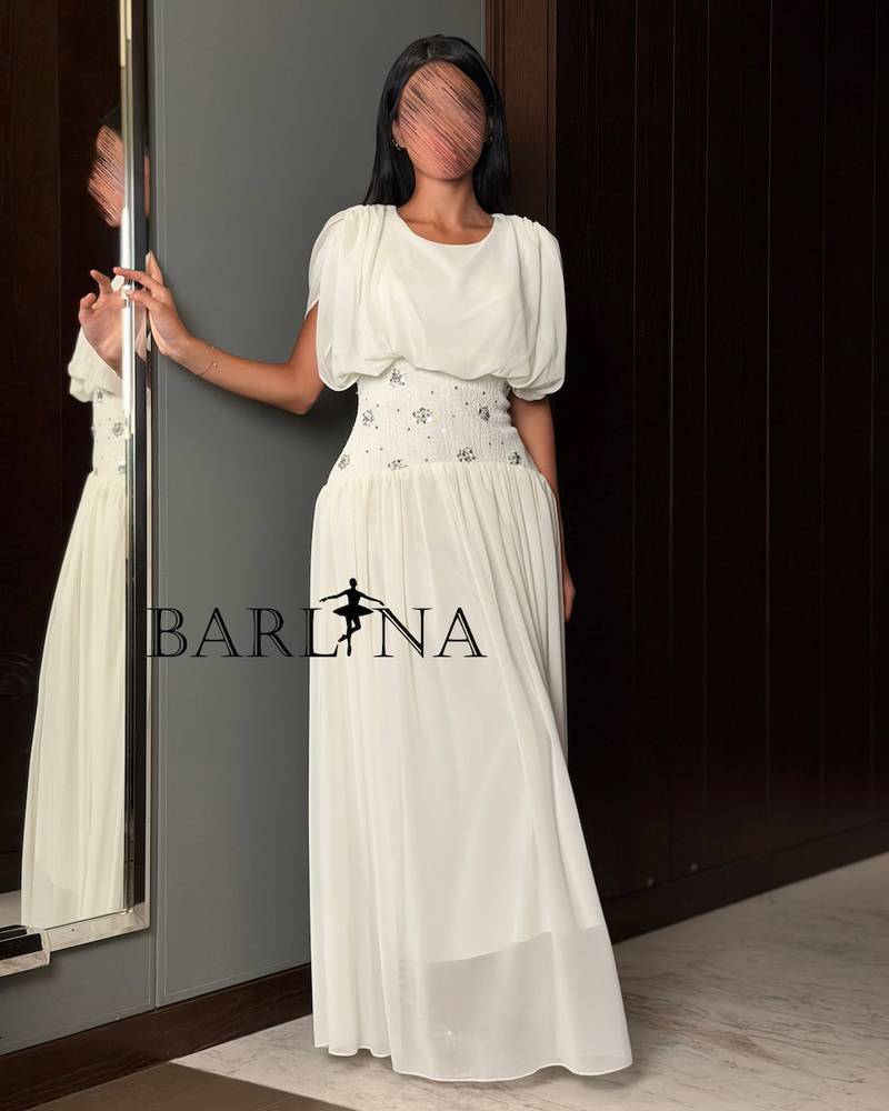 A soft white dress with a waist adorned with elegant details.