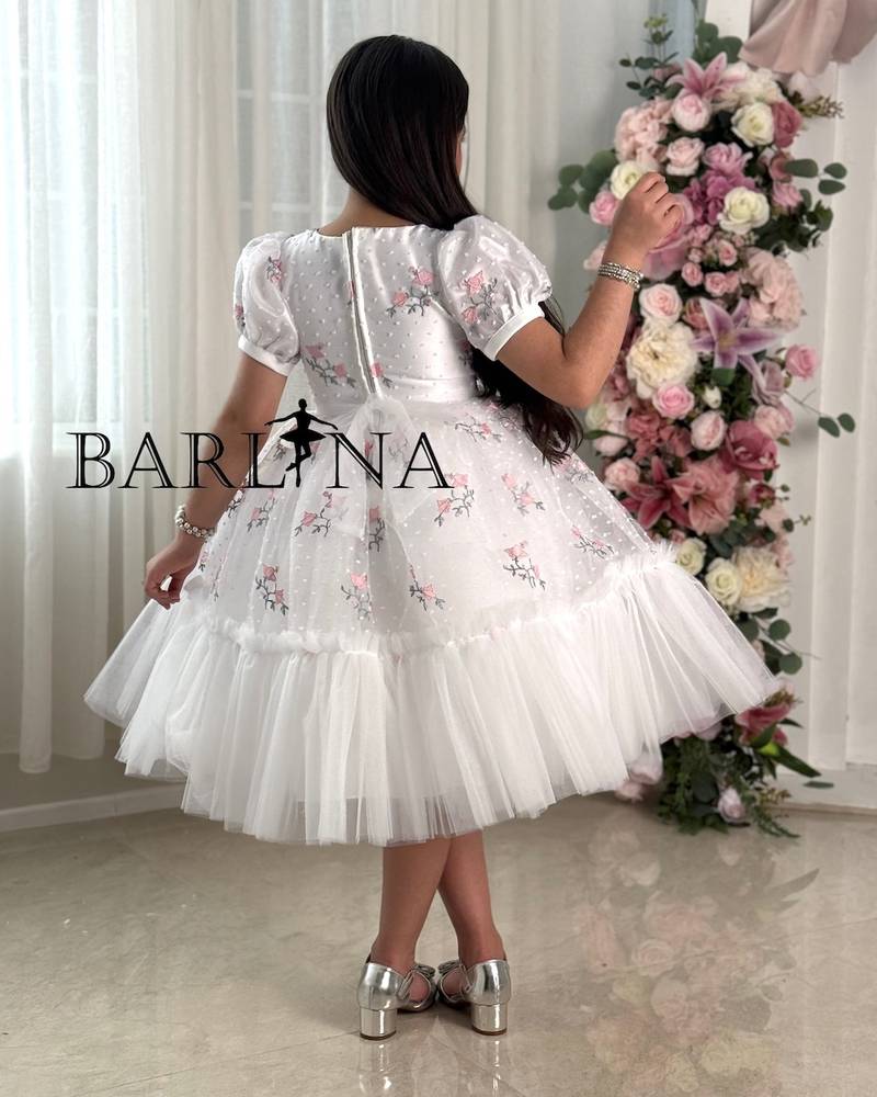 White girl's dress with embroidery and a pink flower