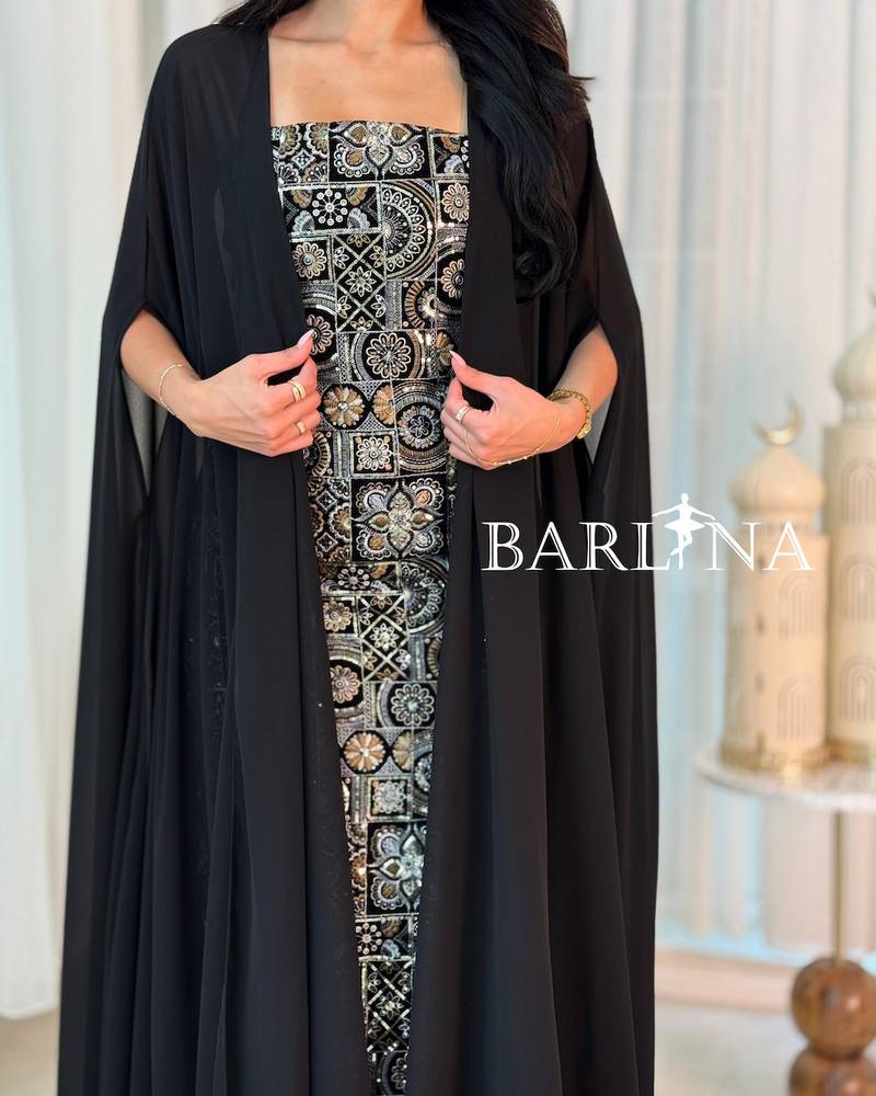 A black jalabiya adorned with luxurious gold patterns