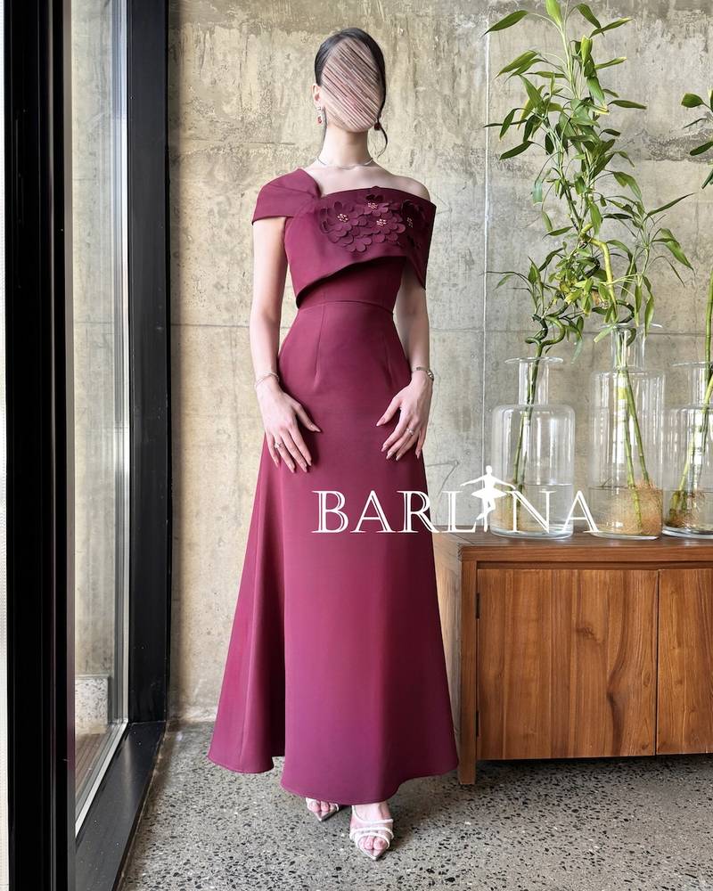 Long burgundy gown with a one-shoulder draped design