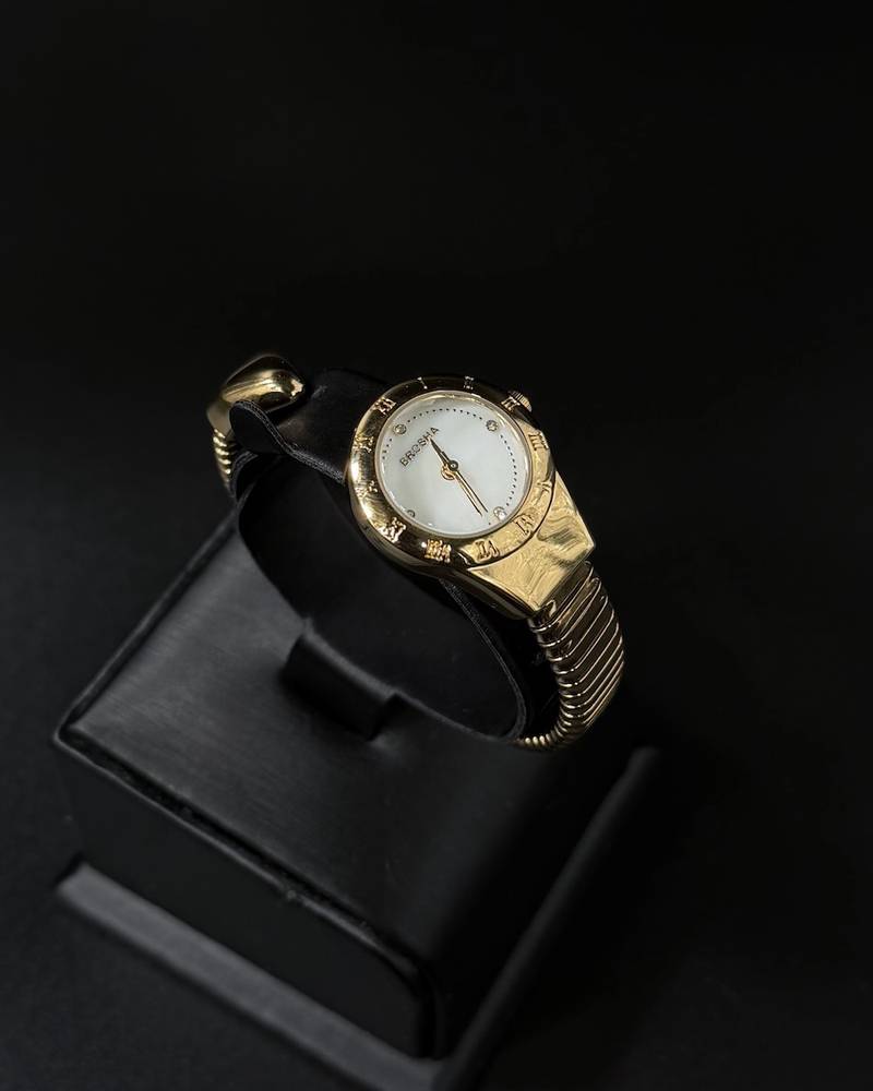 A women's watch with a delicate design and an open strap.