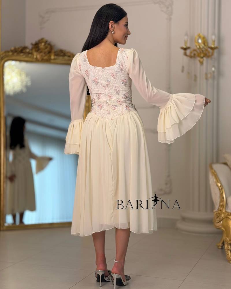 Off-white dress with an embroidered bodice and bell sleeves