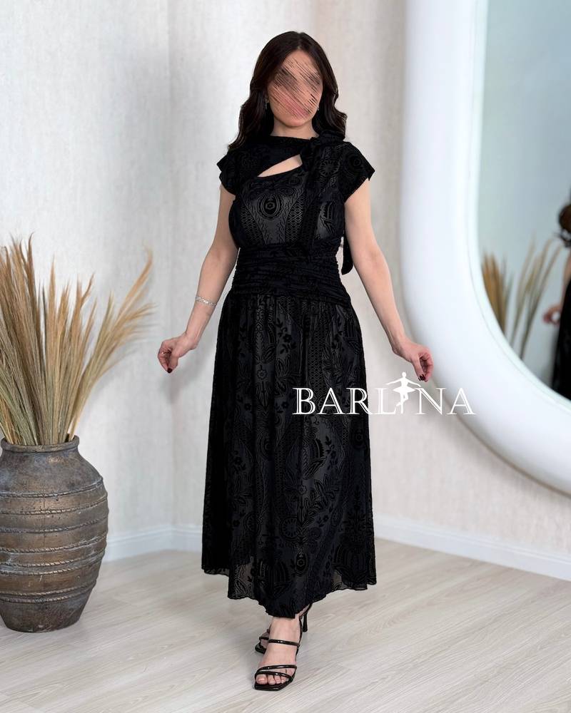 Black dress with an asymmetrical neckline and a slit