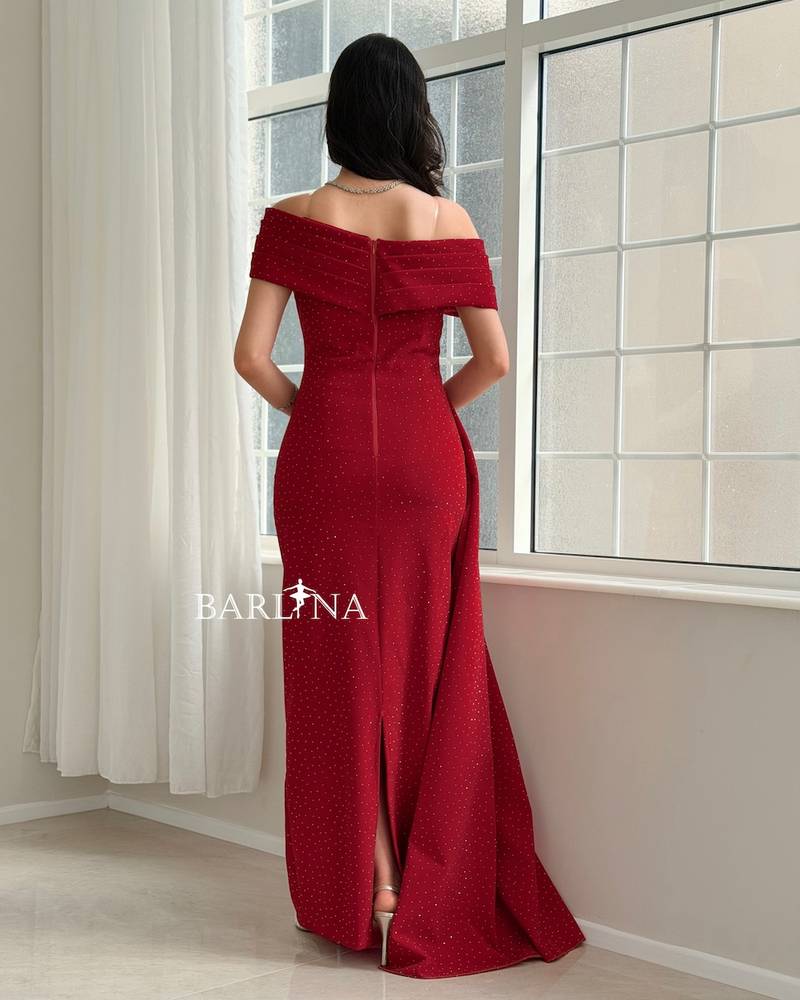 Red dress adorned with small rhinestones and a side train