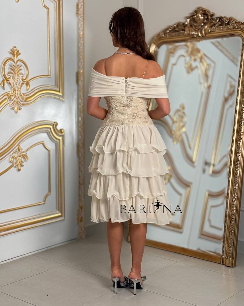 Ivory layered dress with an off-the-shoulder neckline