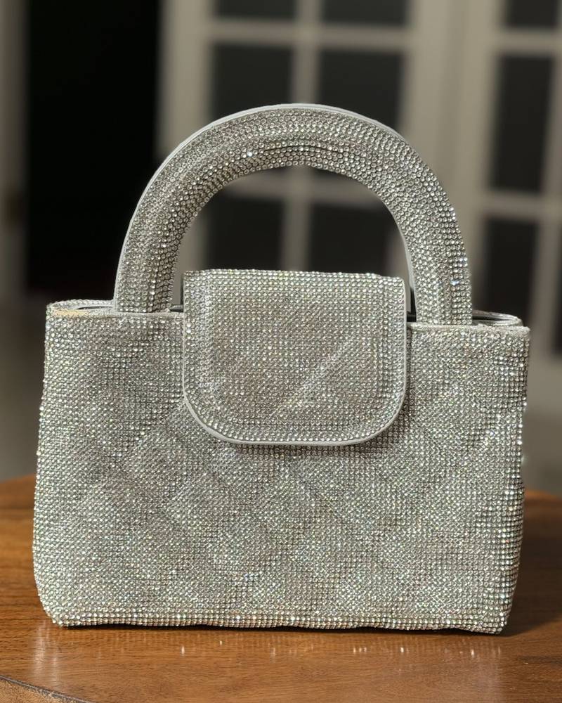 A square-shaped handbag with a stylish wide handle.