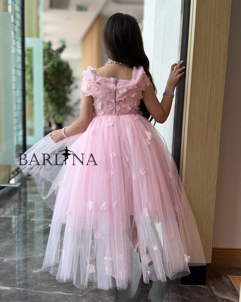 Pink girl's dress decorated with roses on the shoulder
