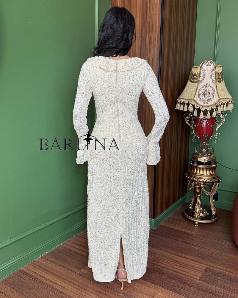 An ivory dress adorned with embroidery and shimmering details.