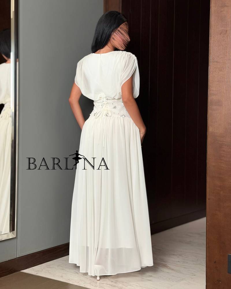 A soft white dress with a waist adorned with elegant details.