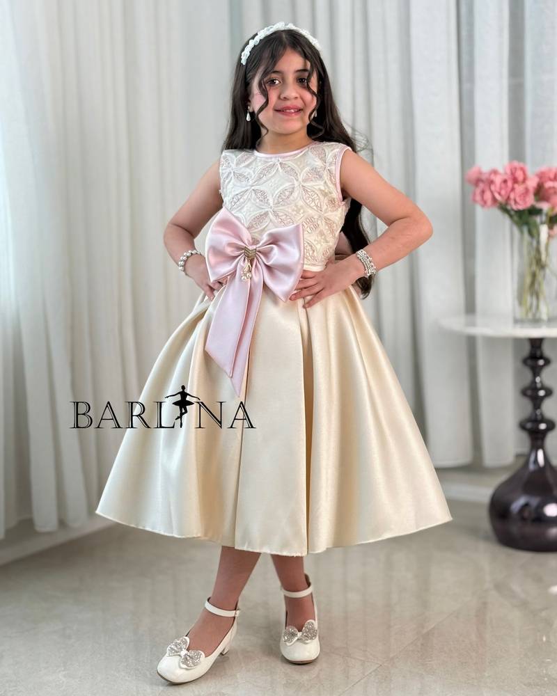 Beige girl's dress decorated with a pink bow