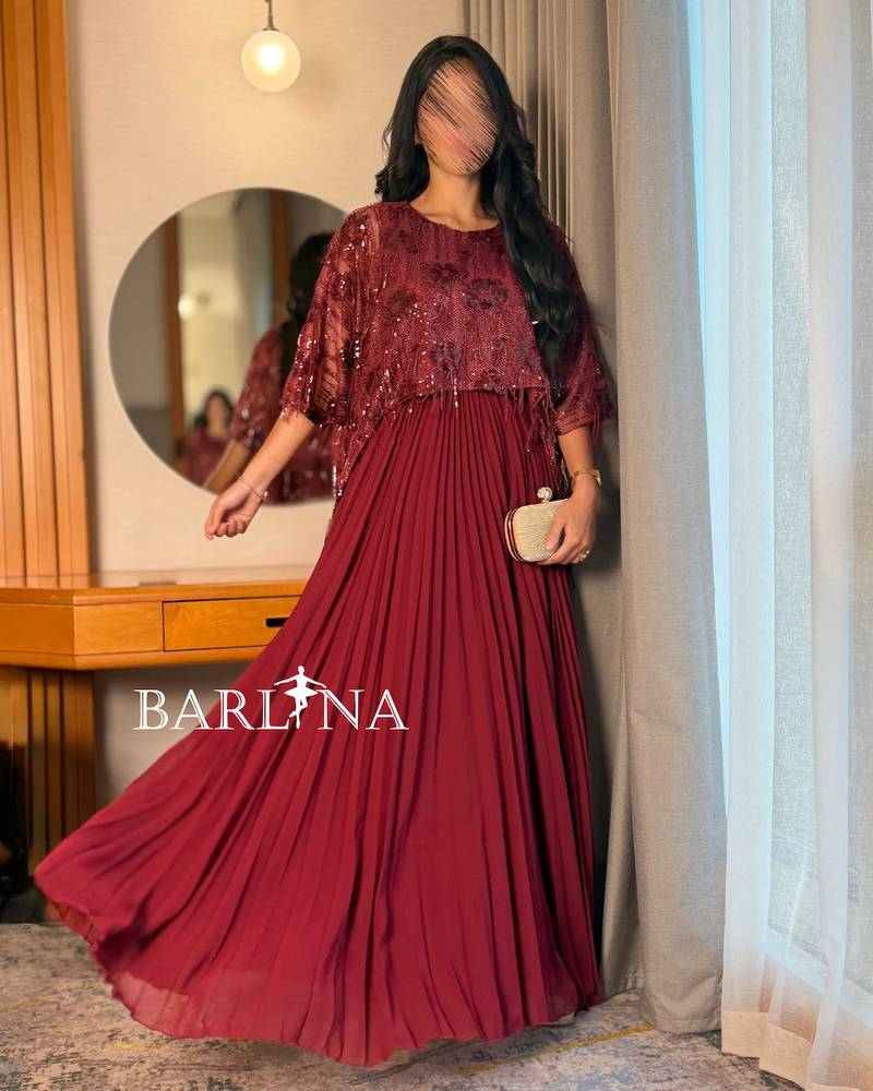 A wide, burgundy dress with shimmering sequins and soft pleats