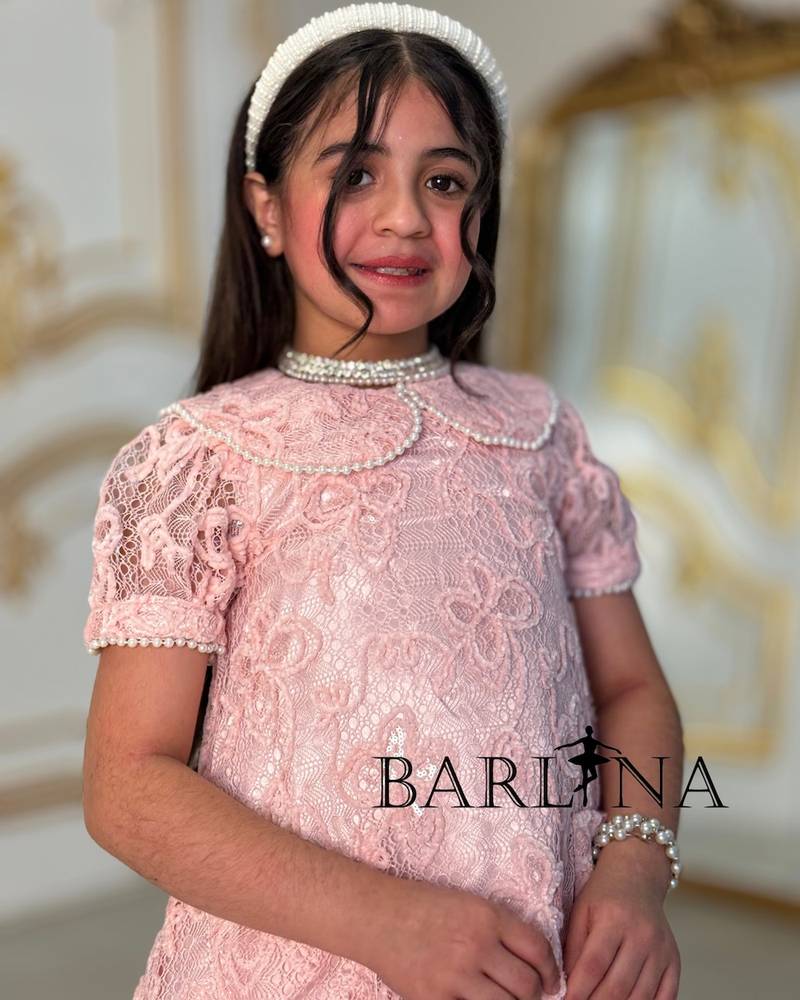A soft girl's dress with lace and feather trim