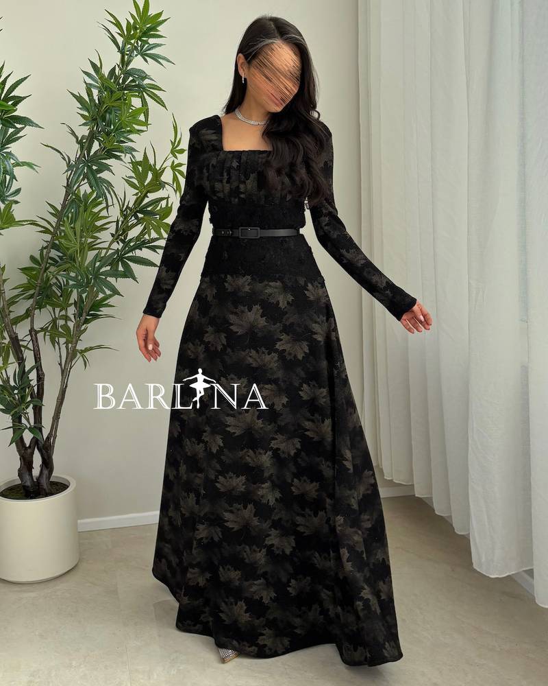 A soft black dress with a subtle pattern and a thin belt