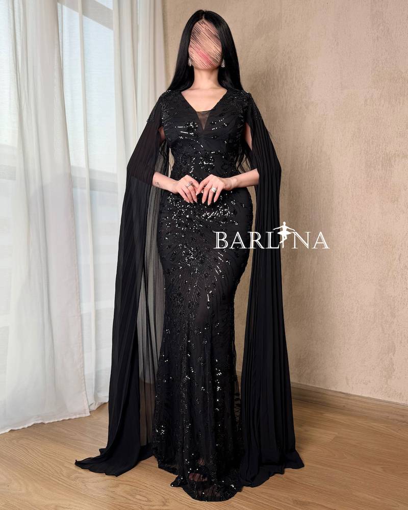 Black dress with shimmering embroidery and a long cape