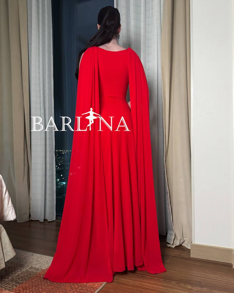 Red dress with a long cape falling from the shoulders