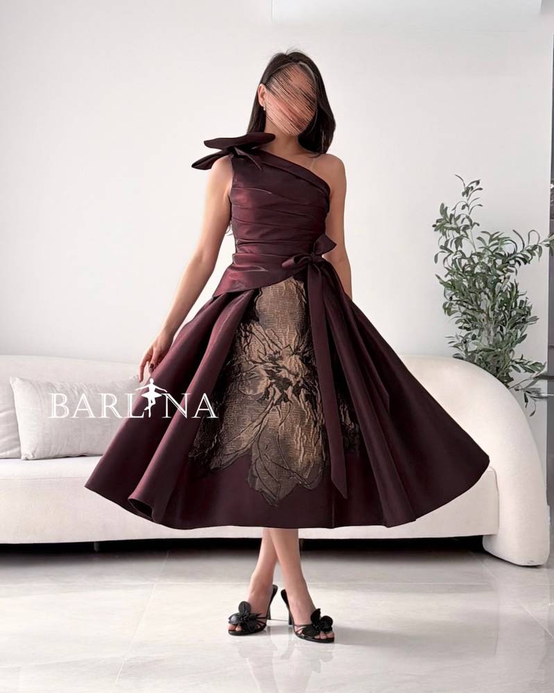 One-shoulder brown dress with a large gold rose