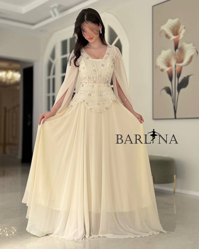Off-white dress with a royal design and a long cape