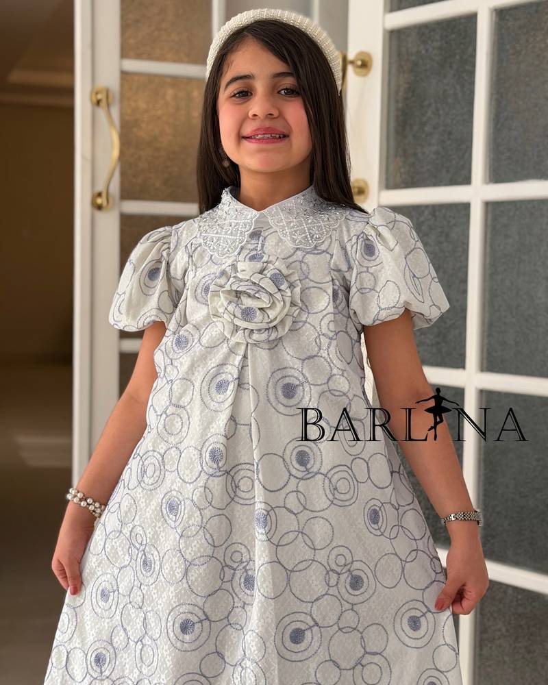 A girl's dress decorated with circle patterns and a raised rose