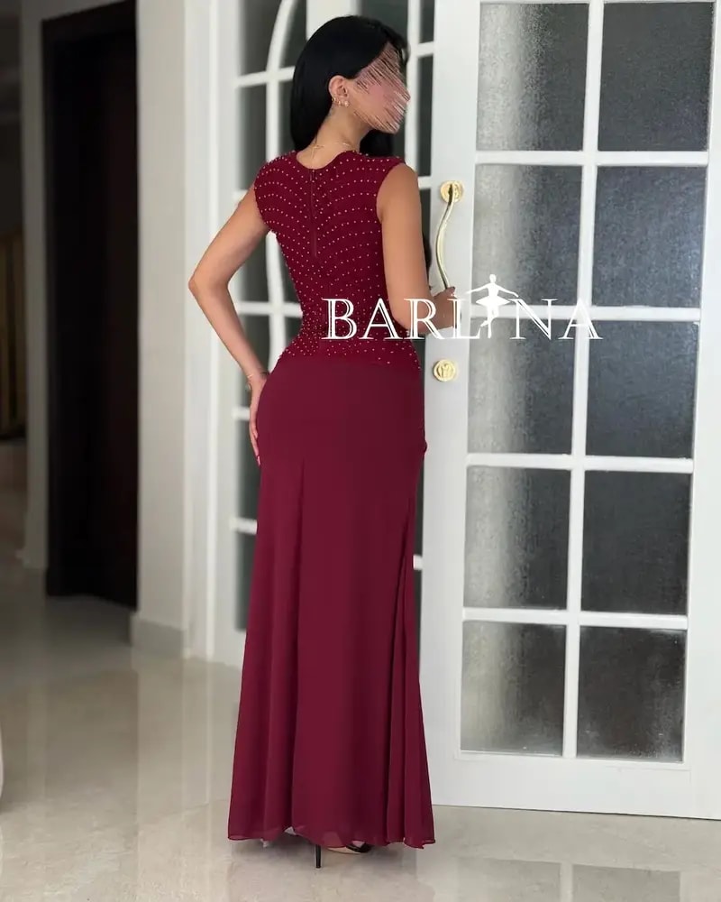 A red dress with shimmering embroidery and a flowing silhouette.