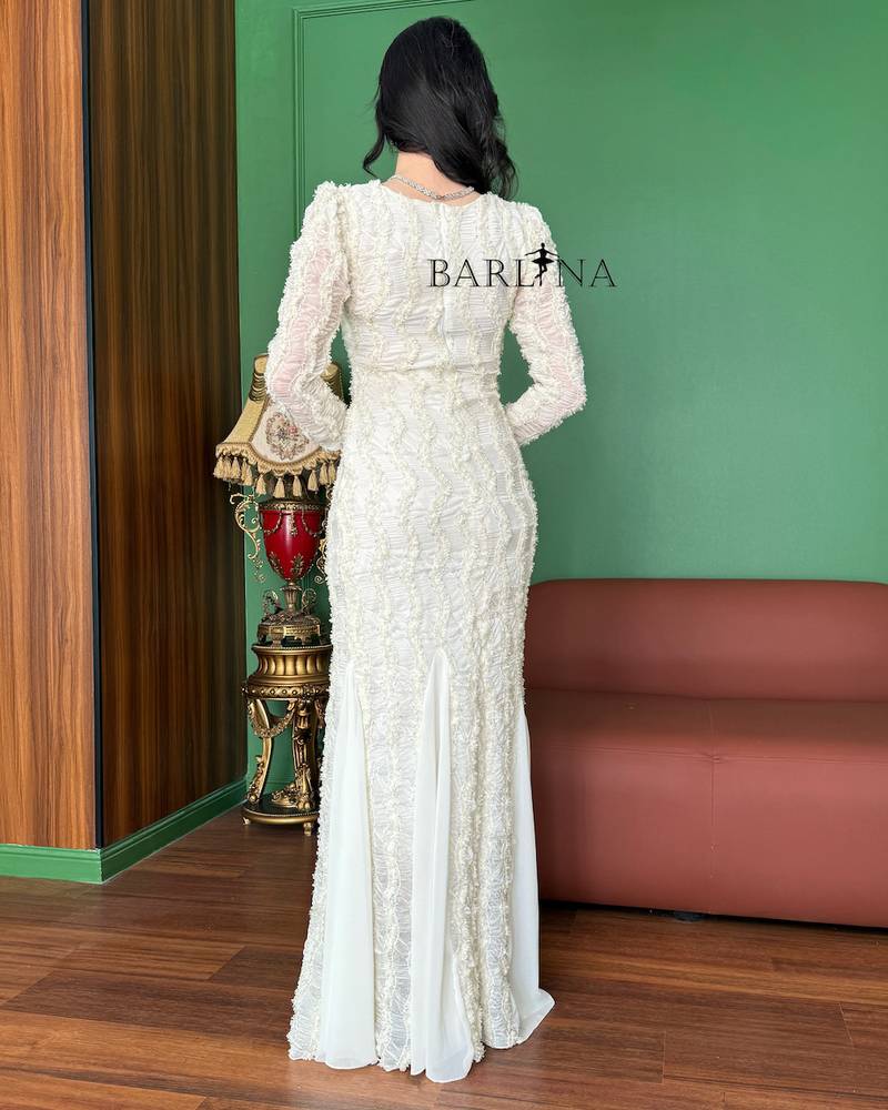 Long white dress with sheer sleeves and a flowing silhouette