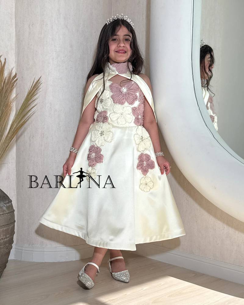 An off-white girl's dress decorated with elegant roses