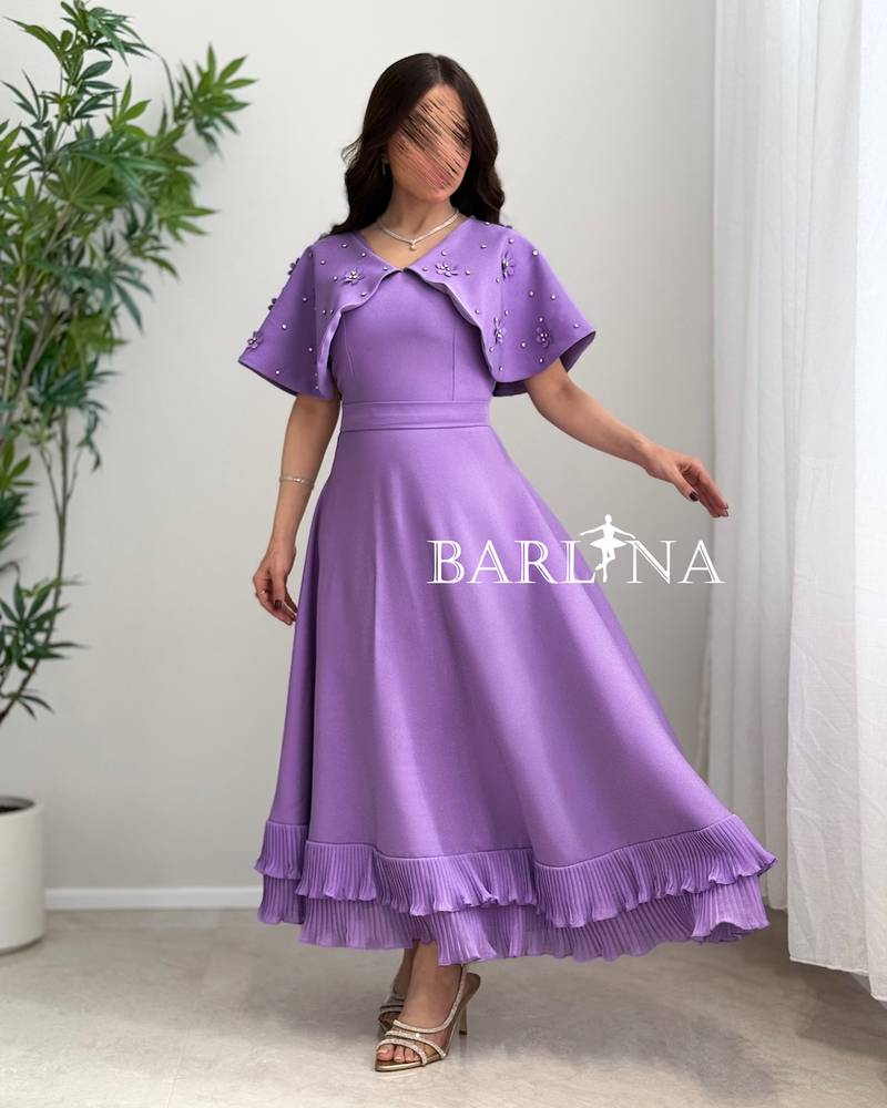 Dress with embroidered cape and pleats at the bottom