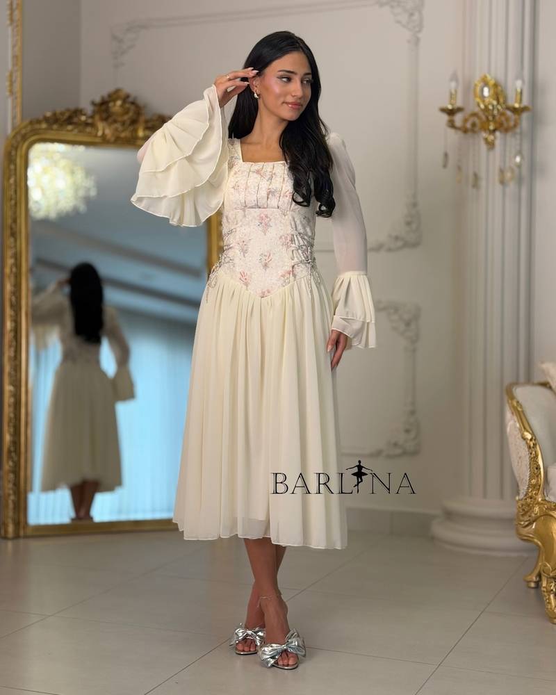 Off-white dress with an embroidered bodice and bell sleeves