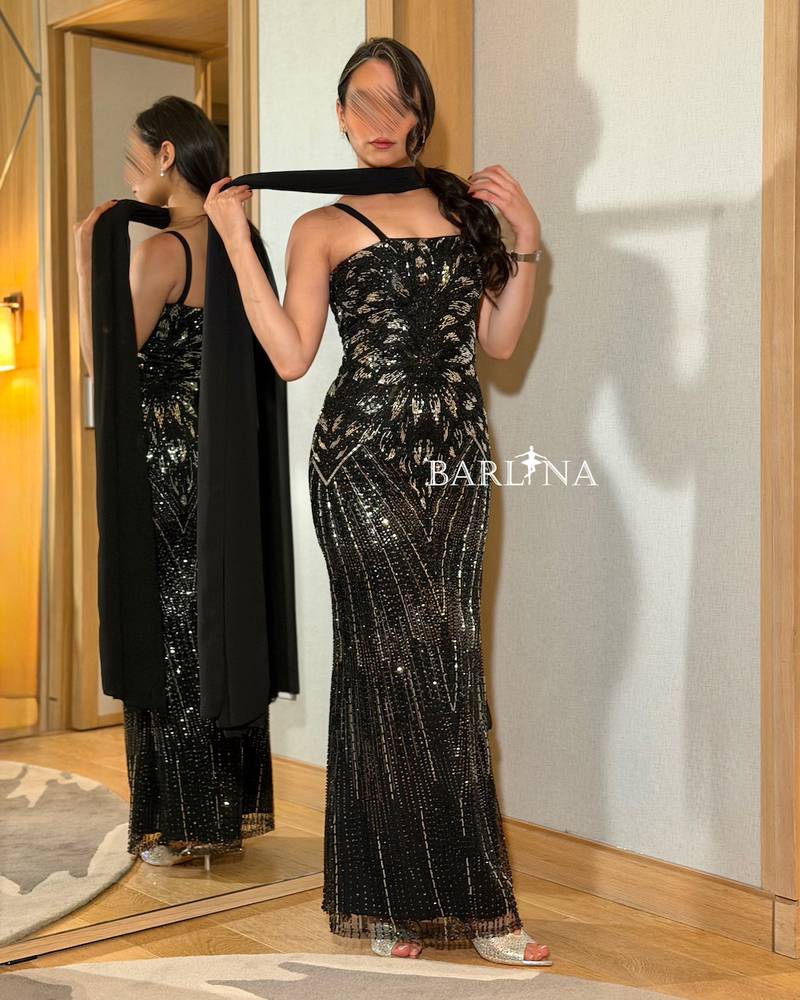 A black dress embroidered with shimmering sequins in an elegant pattern
