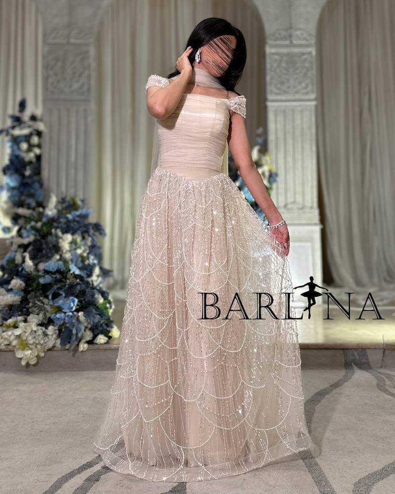 فستان تل بيج فاخر مزين بتطريزات لؤلؤية