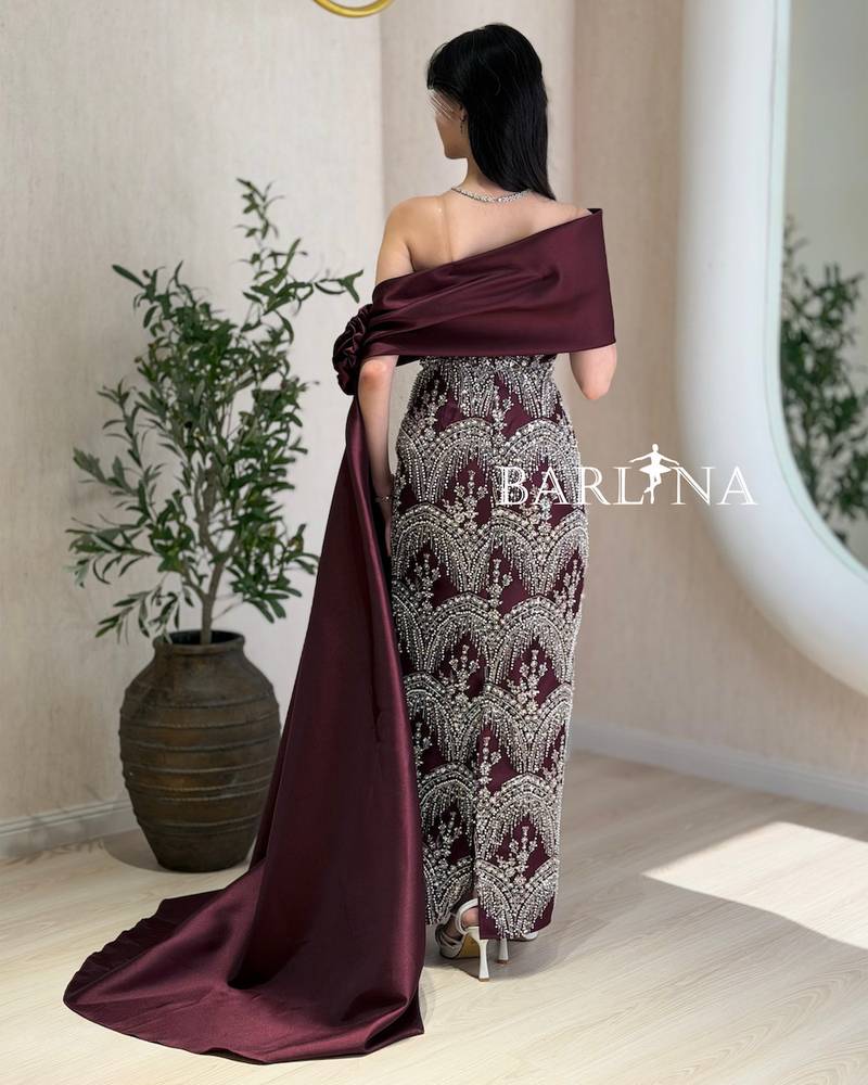 A burgundy dress with silver embroidery and a matching train.