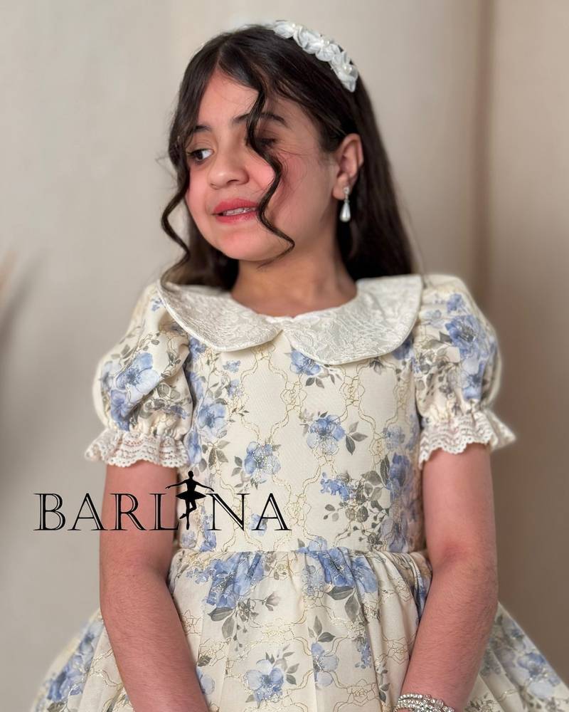 A classic off-white girl's dress with a floral print