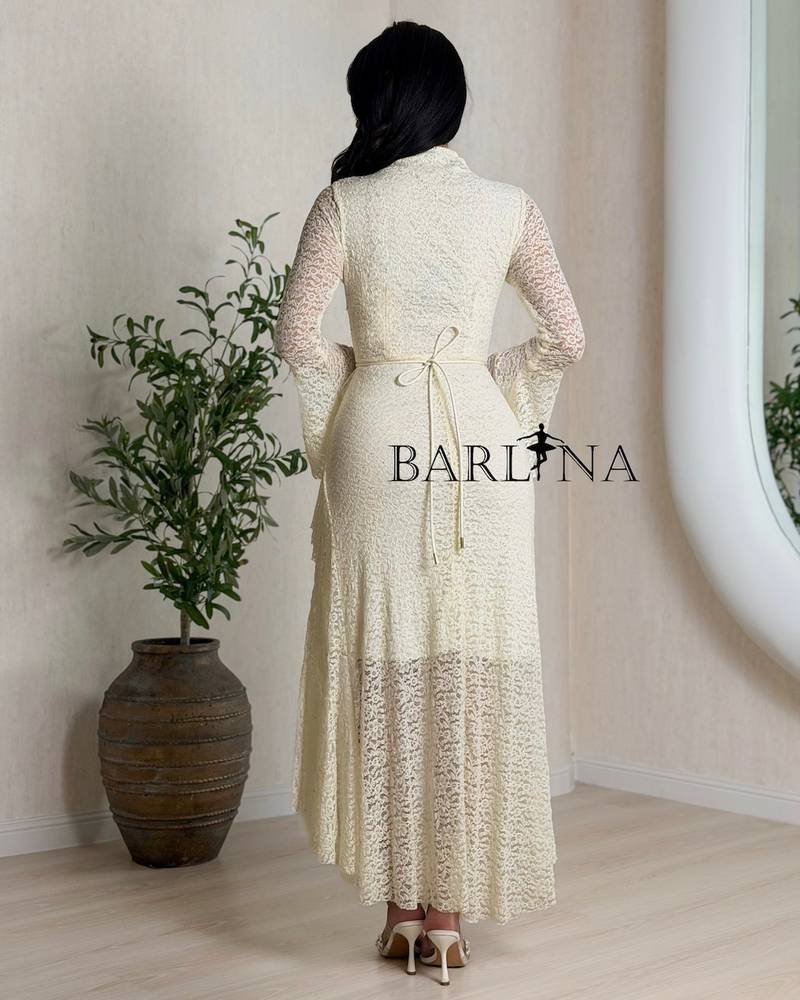 Off-white dress with ruffles at the waist and a gold belt