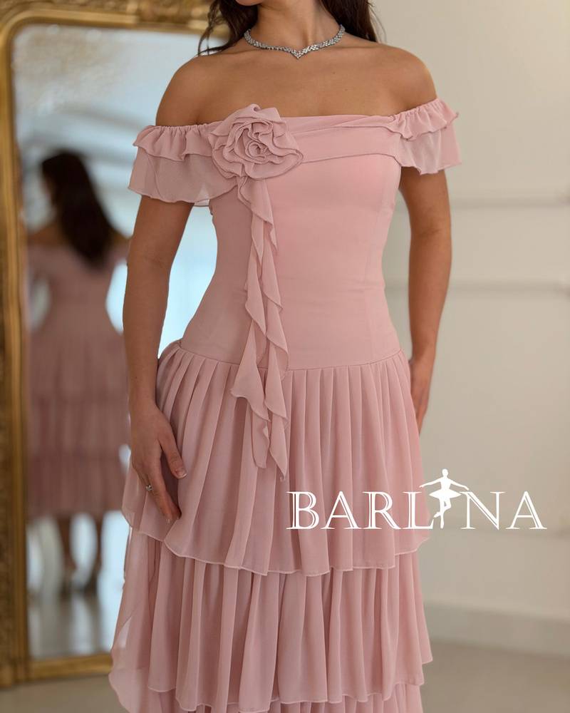 A soft, layered dress with a fabric rose.