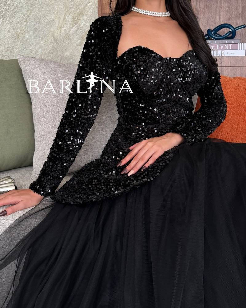 فستان أسود بأكمام طويلة وبقصة البيبلوم