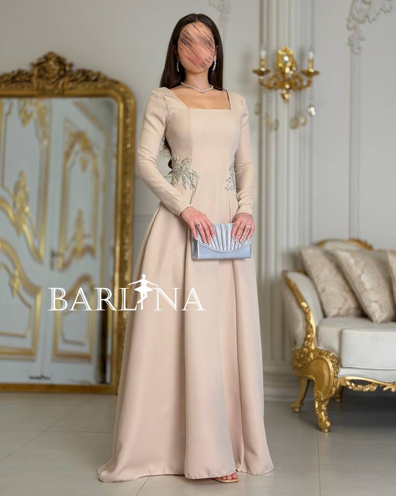 Long beige dress adorned with luxurious embroidery