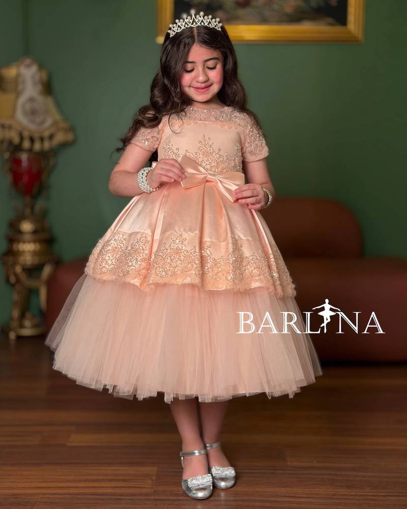 Girls' dress in a peach color with short sheer sleeves