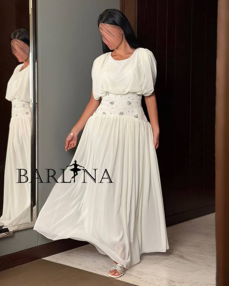 A soft white dress with a waist adorned with elegant details.