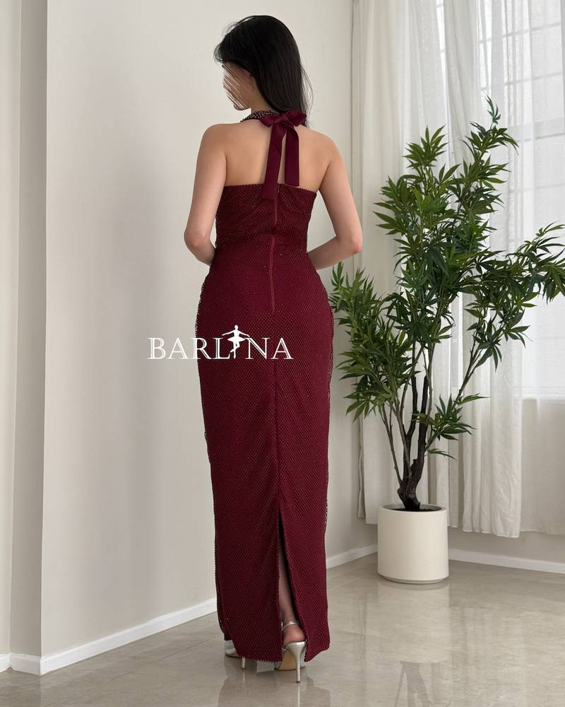 A long, elegant burgundy halter-neck dress