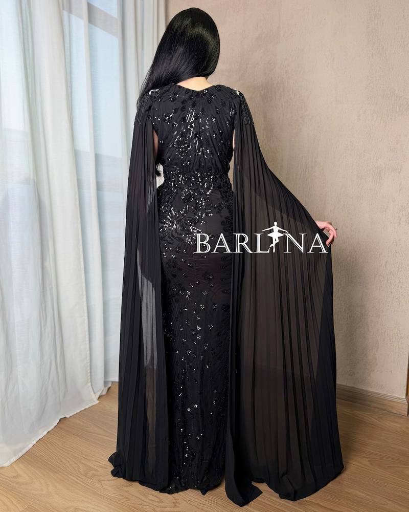 Black dress with shimmering embroidery and a long cape