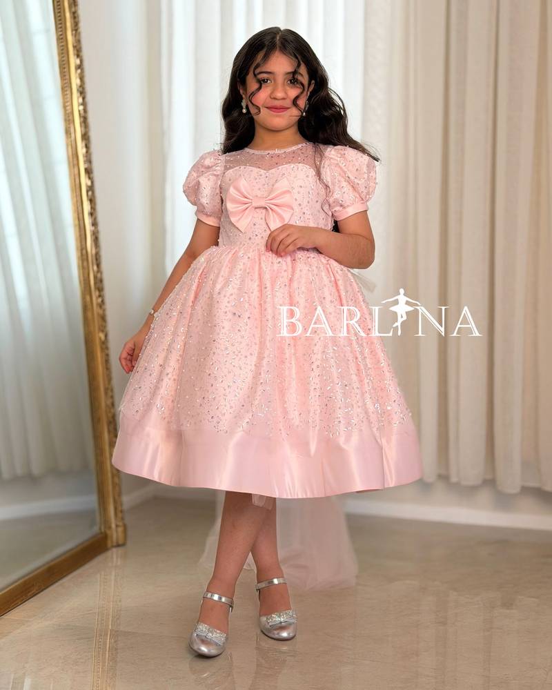 A shiny pink girl's dress decorated with sparkly details