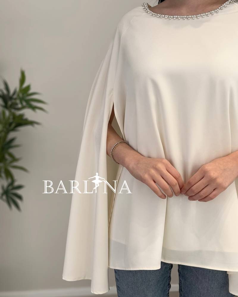 A soft blouse adorned with a pearl trim