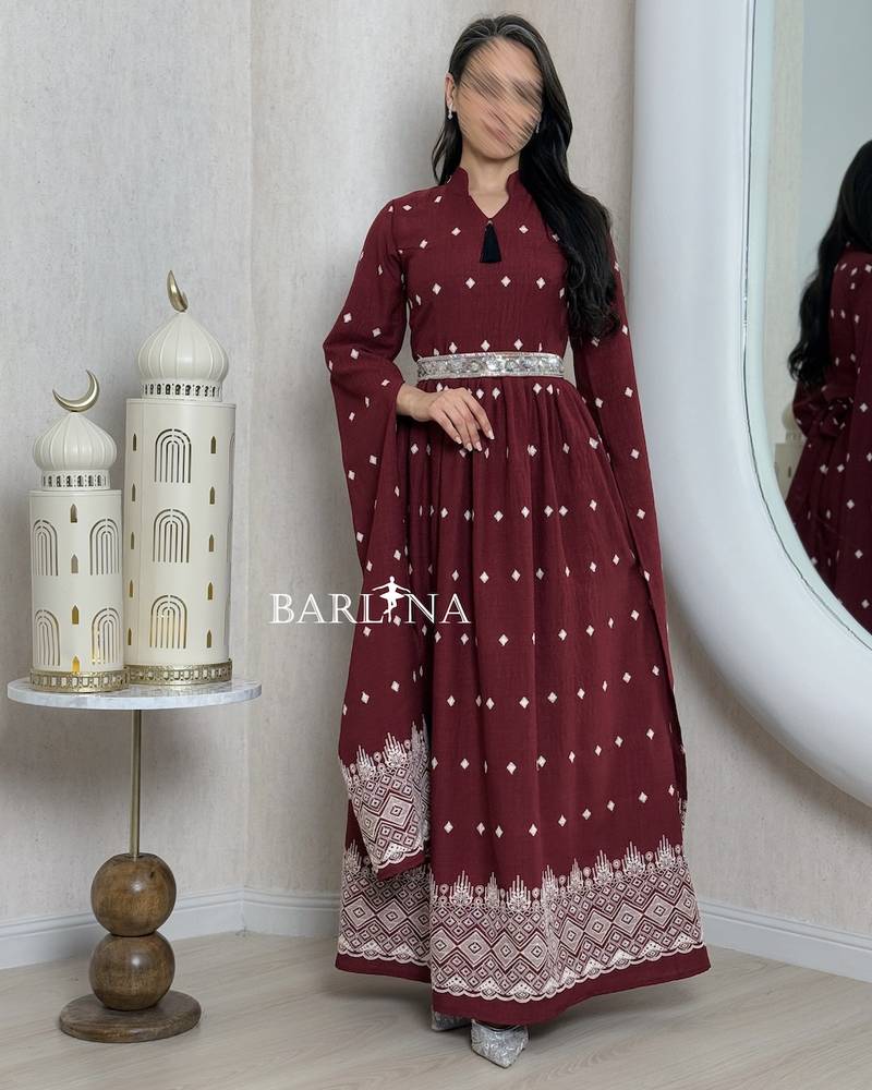 A burgundy-colored jalabiya with scattered patterns