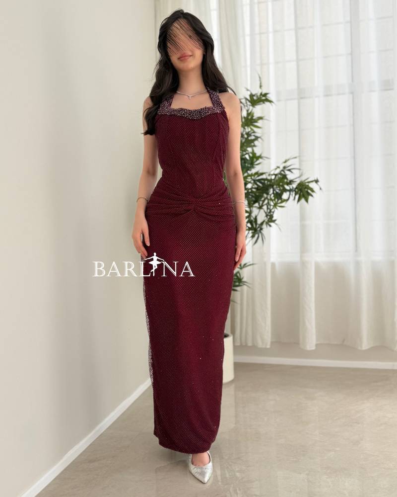 A long, elegant burgundy halter-neck dress