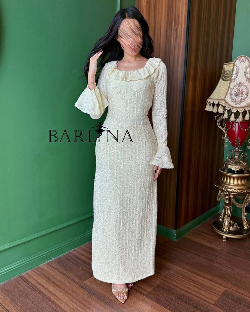 An ivory dress adorned with embroidery and shimmering details.
