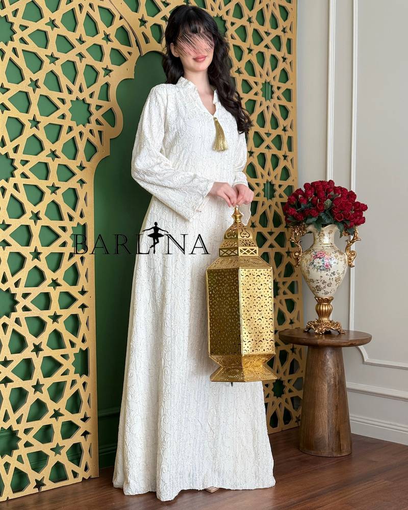 A white jalabiya with delicate embroidery and a straight cut.