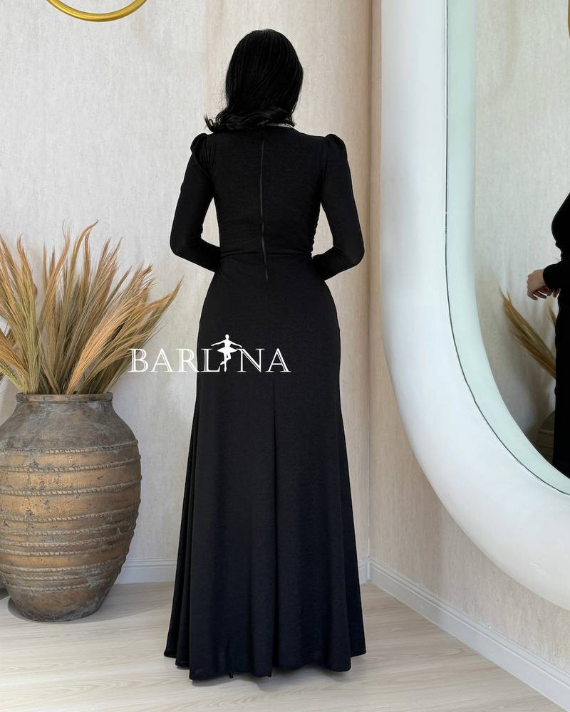 A black wrap dress with an elegant brooch