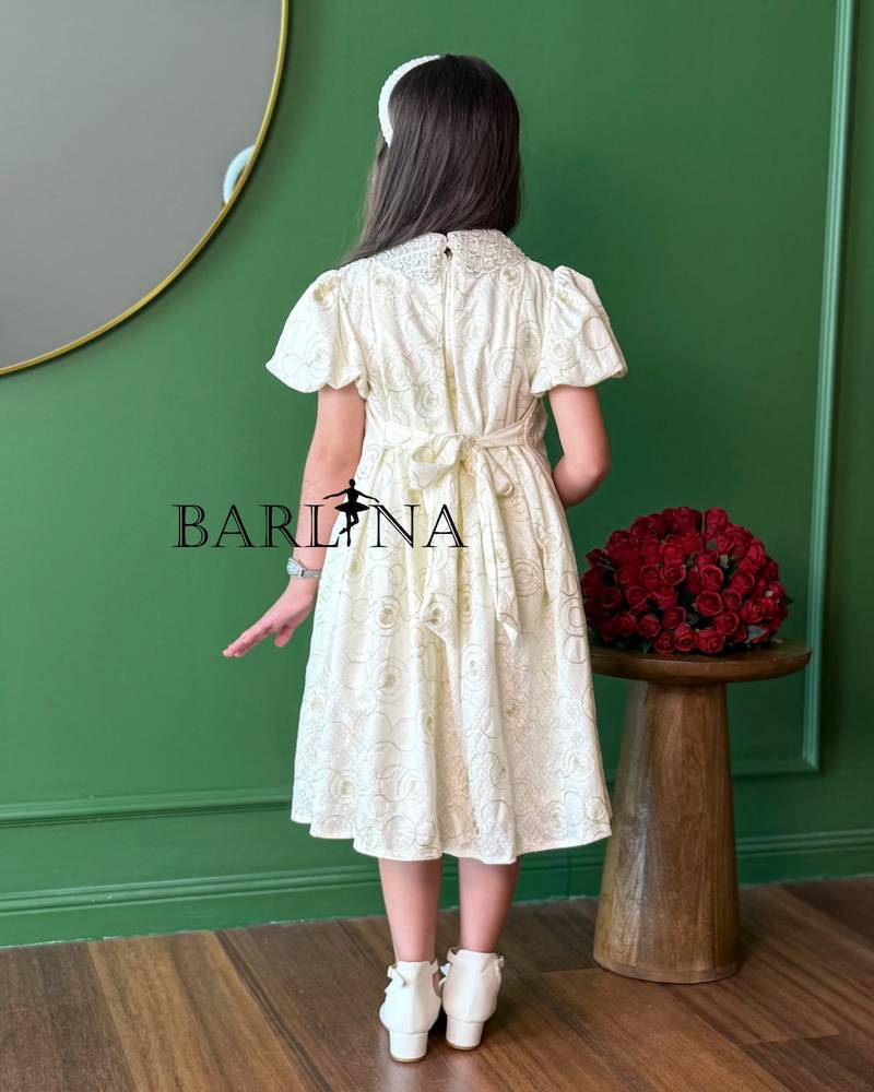 A girl's dress decorated with circle patterns and a raised rose